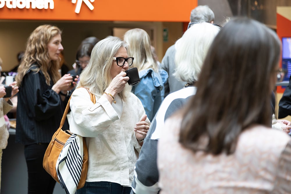 Kvinna dricker kaffe ur kopp 