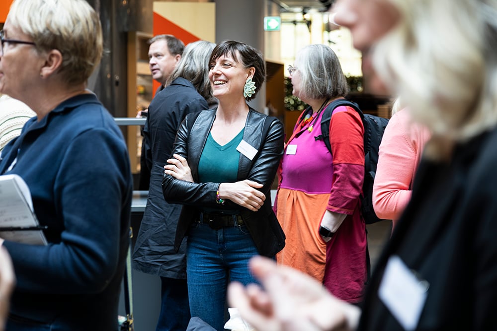 Kvinna i fokus i mingel som skrattar