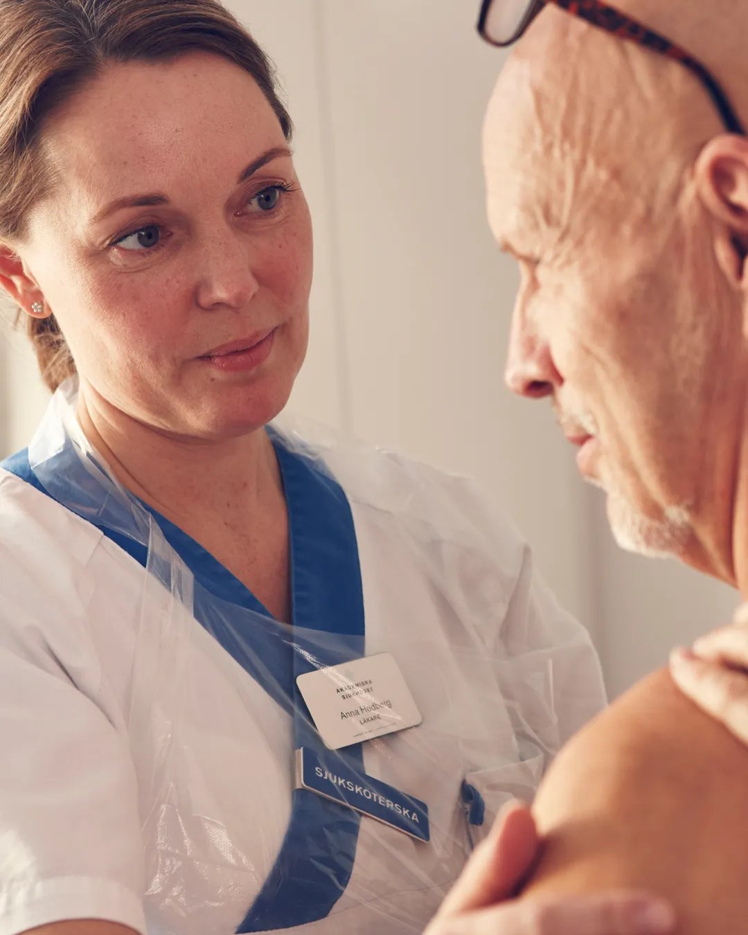 En sjuksköterska som en pratar med en patient.