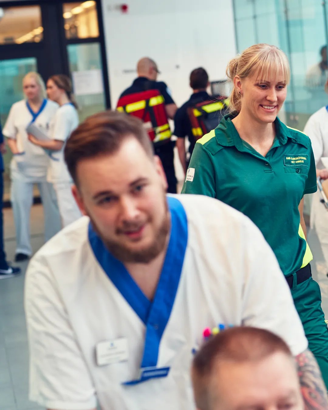 En patient blir skjutsad i rullstol i en sjukhuskorridor.