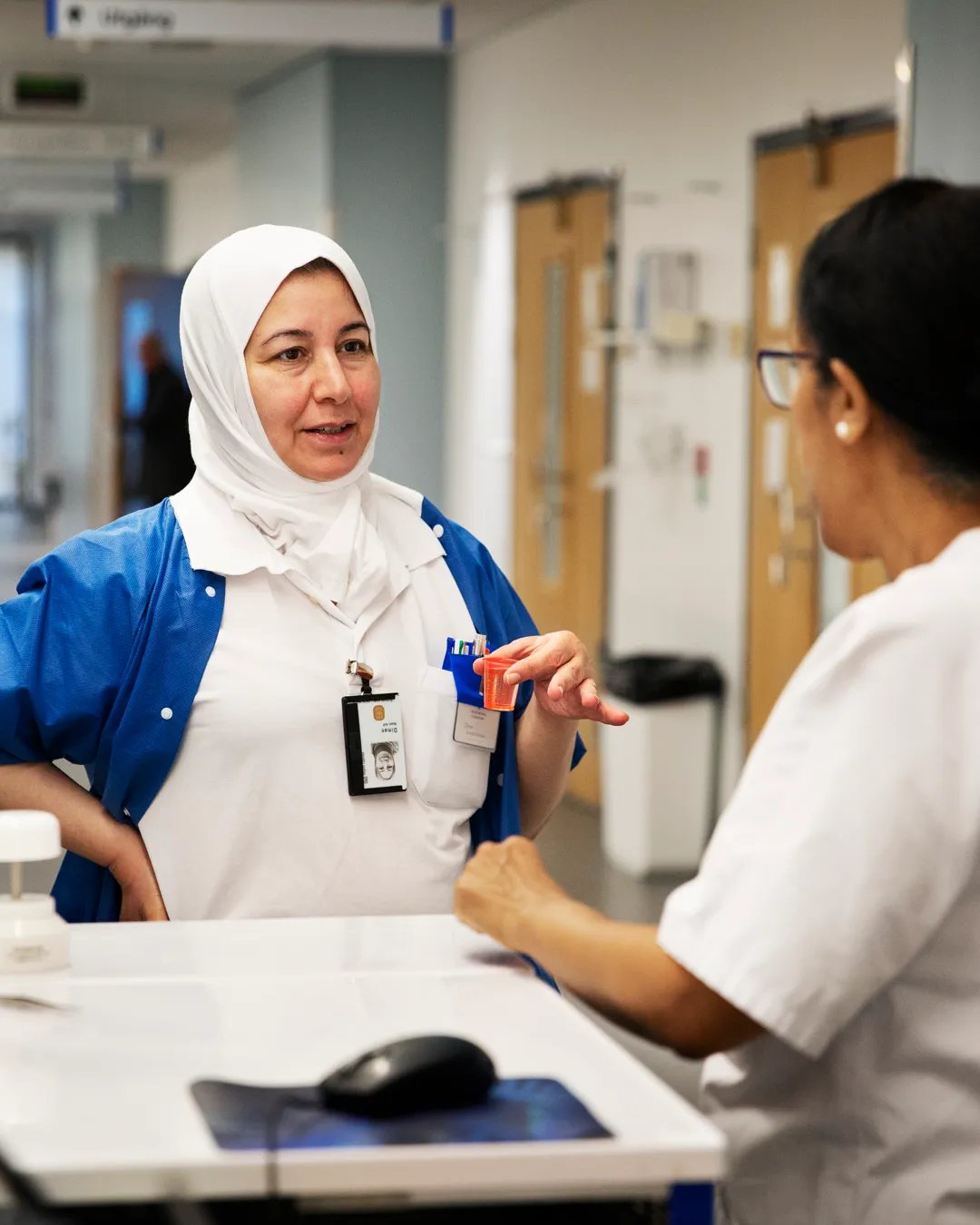 A woman is talking to another woman in a hospital.