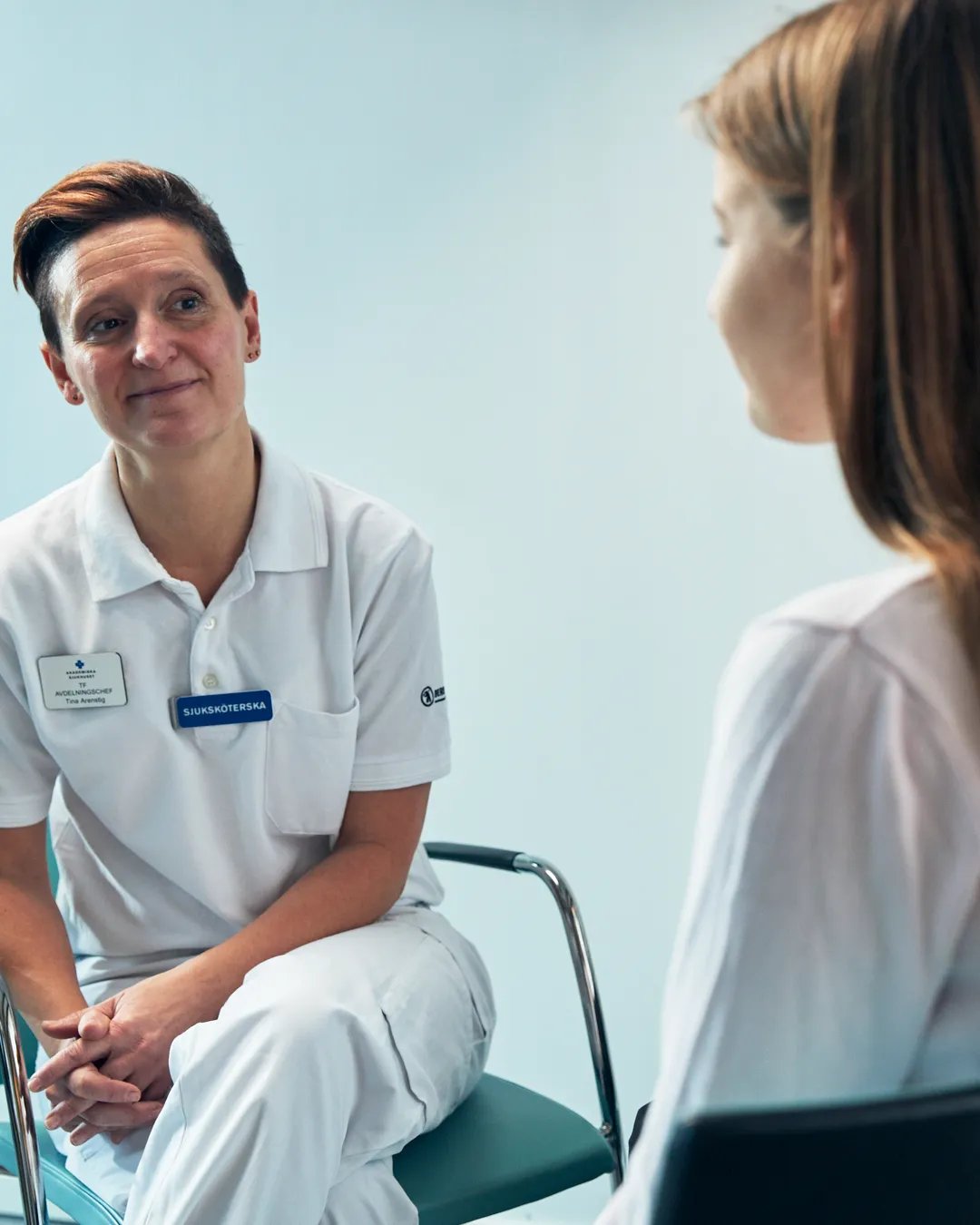 En patient pratar med en sjuksköterska.