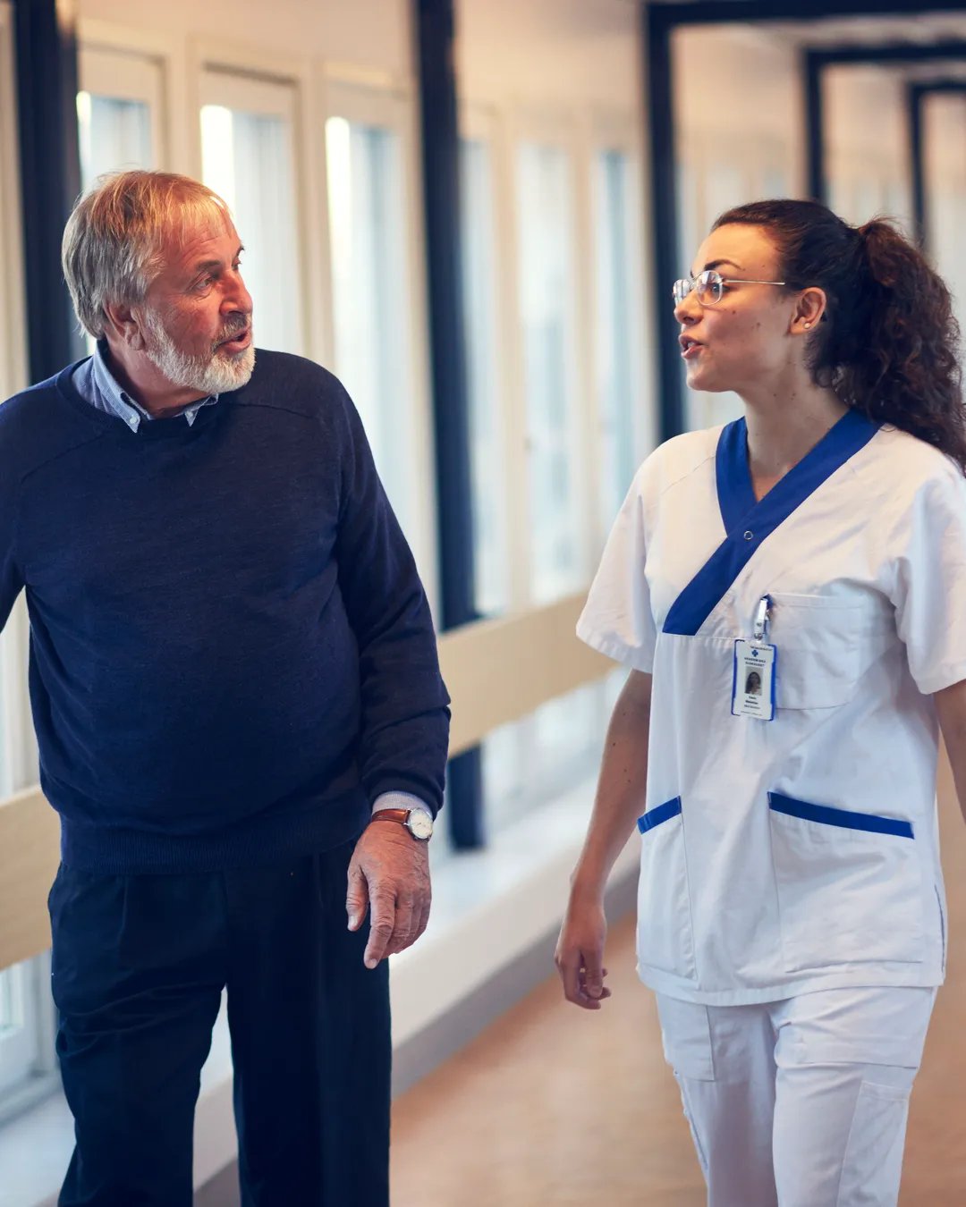 A man and a woman walking down a hallway.