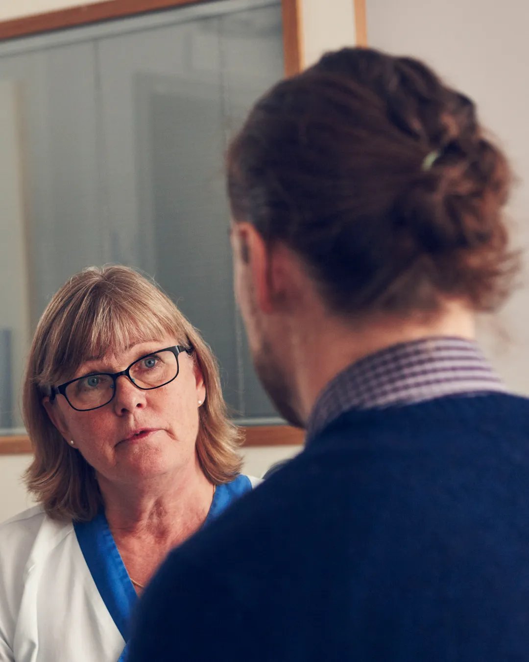 En ögonläkare lyssnar på en patient.