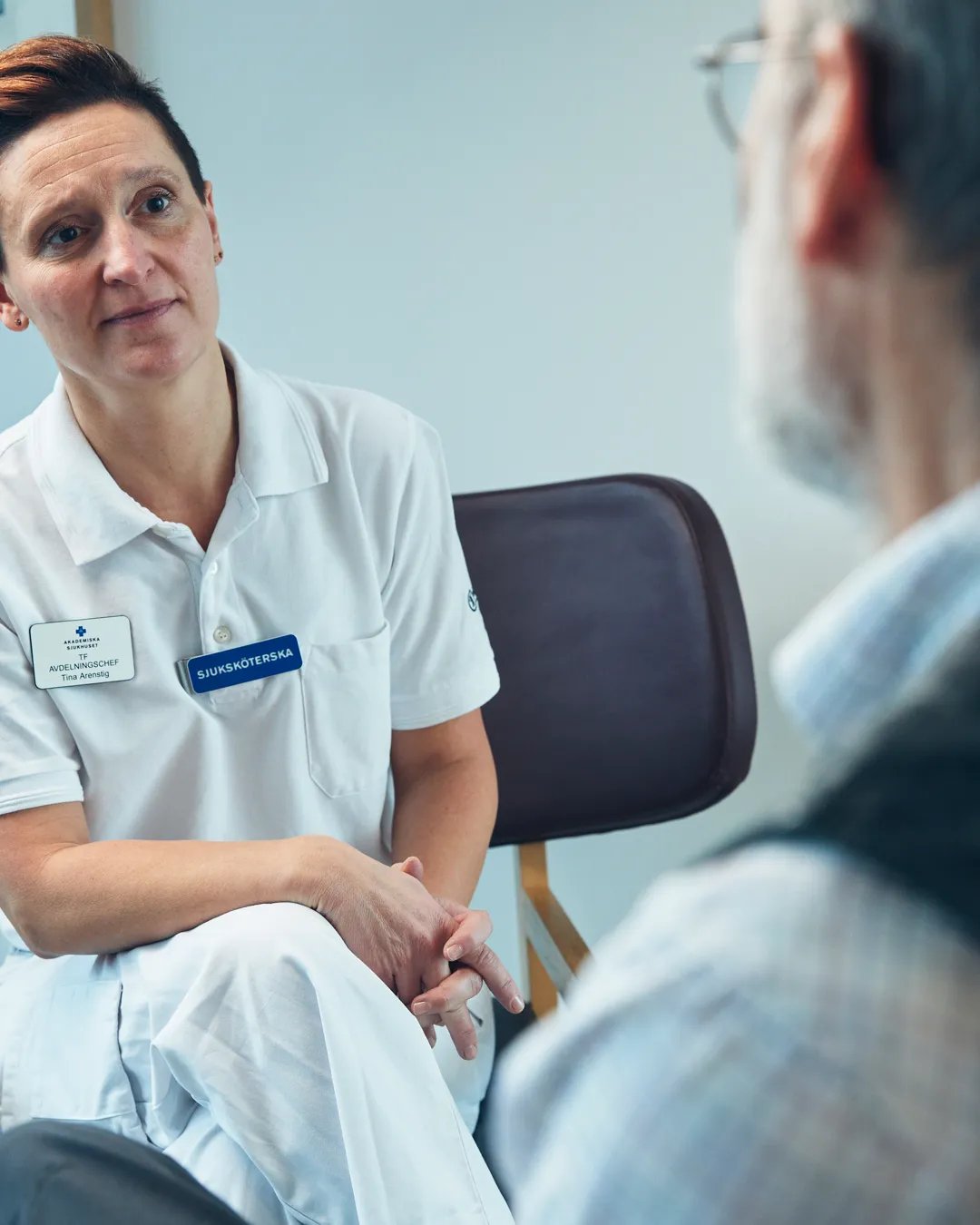 En patient pratar med en sjuksköterska.