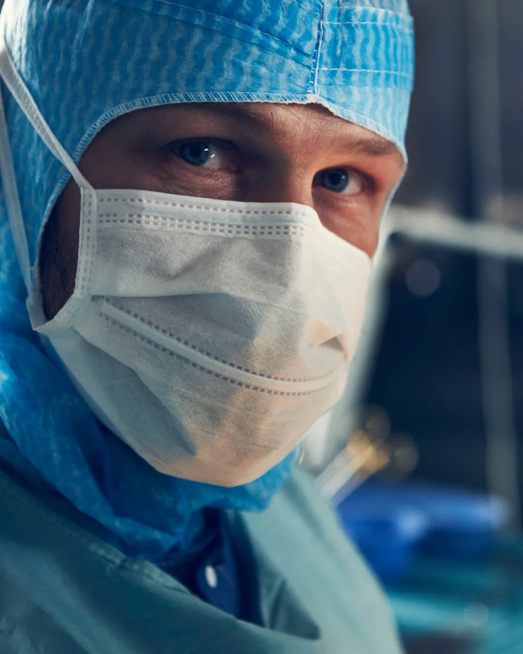 En kirurg med kirurgmask och operationskläder.