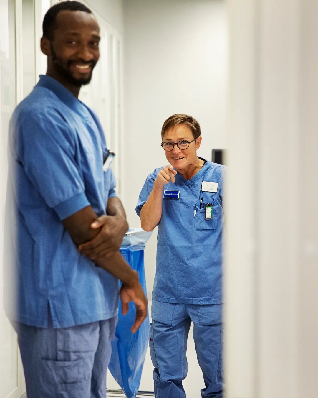 A man and a woman standing in a hallway.