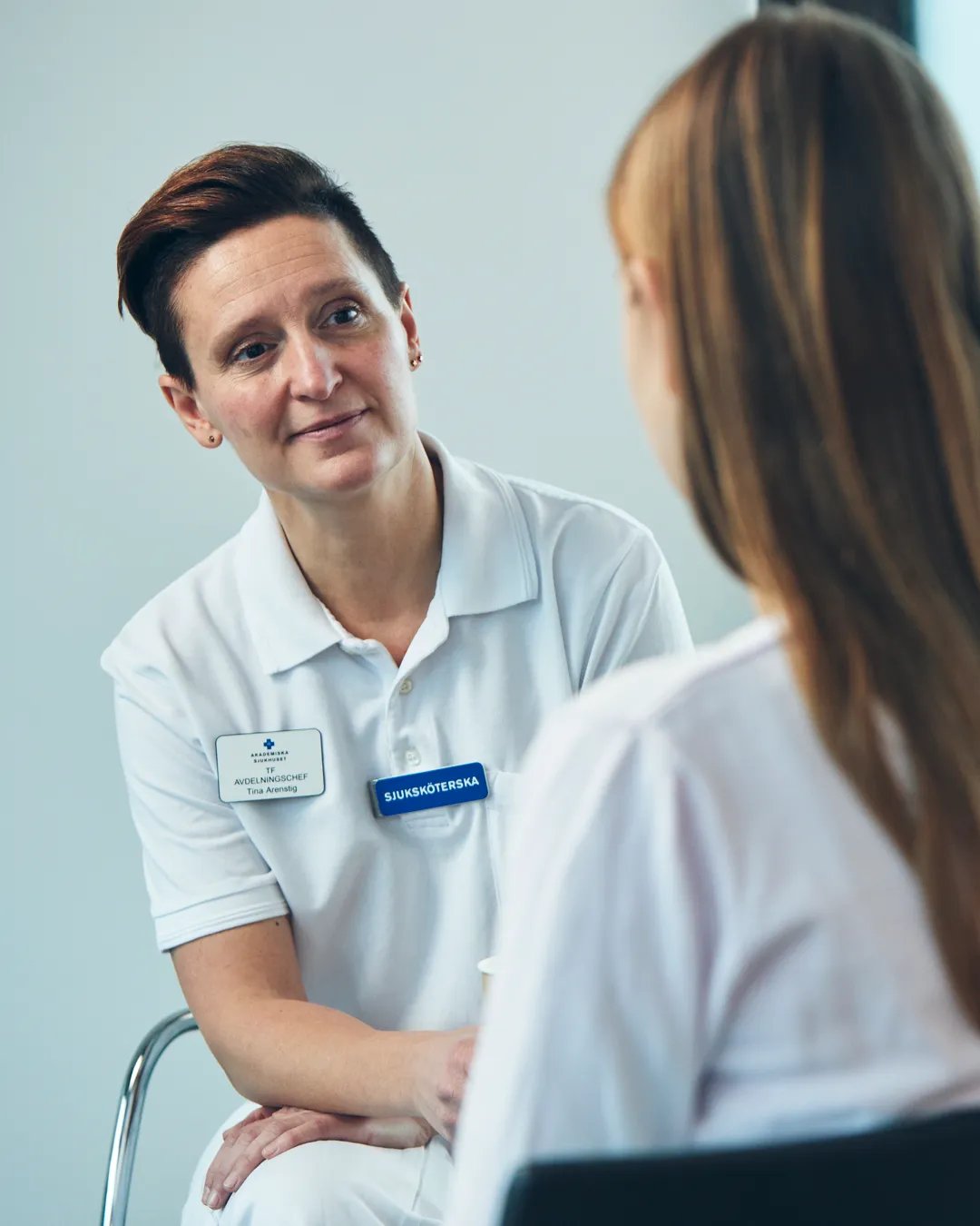 En patient pratar med en sjuksköterska.