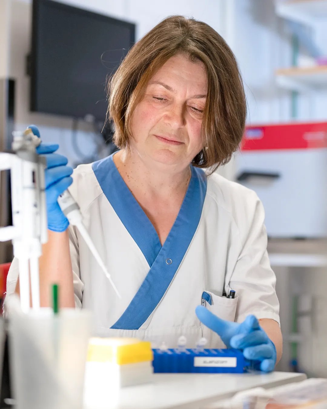 En läkare i ett laboratorium använder en medicinsk pipett.