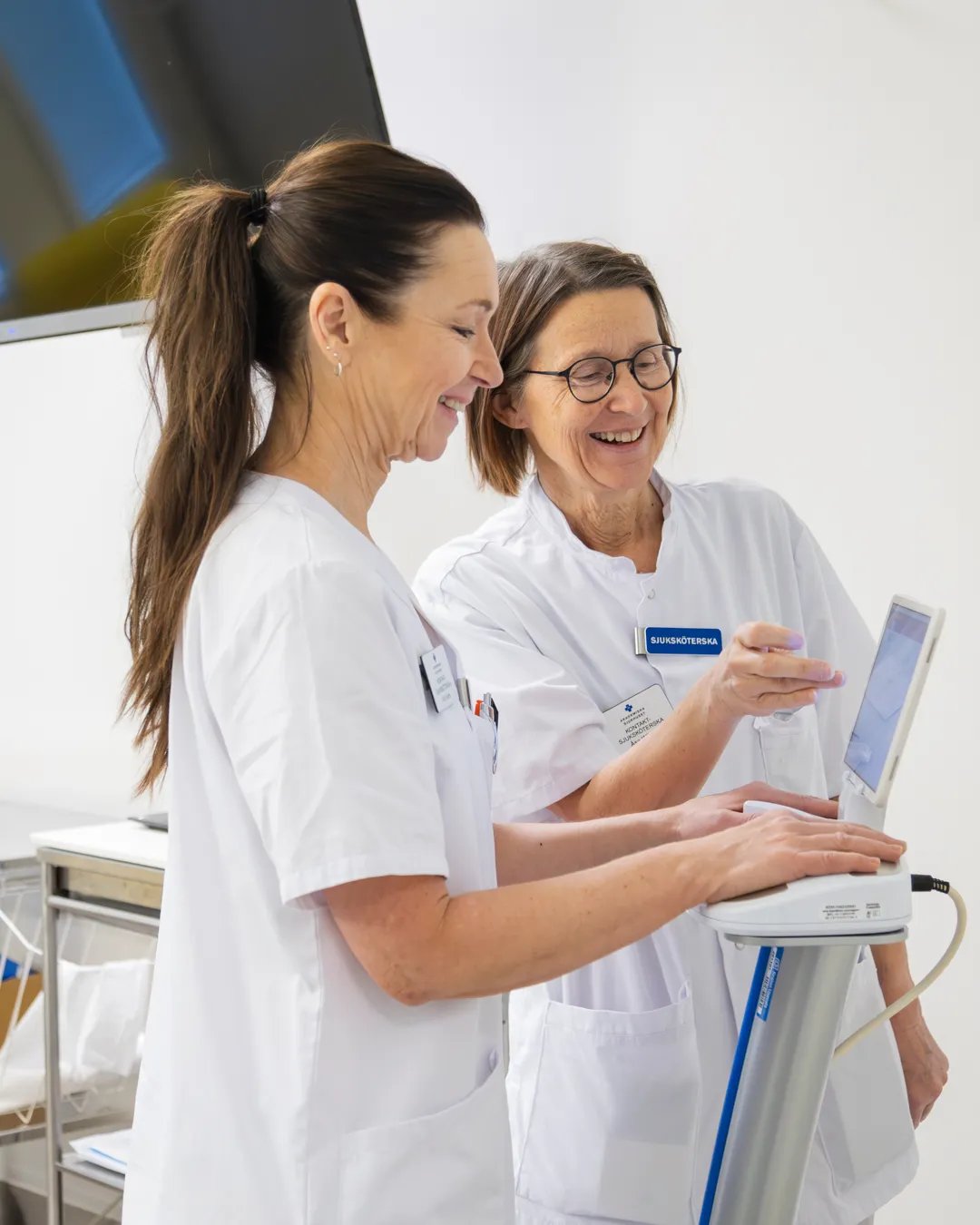 En sjuksköterska och en patient som tittar på en datorskärm.
