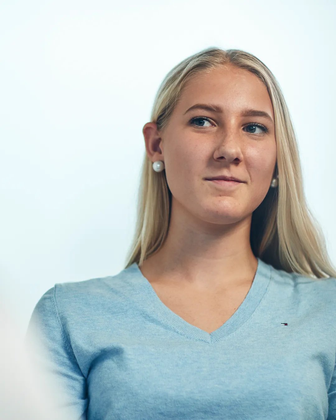 En kvinna i blå tröja pratar med en man.