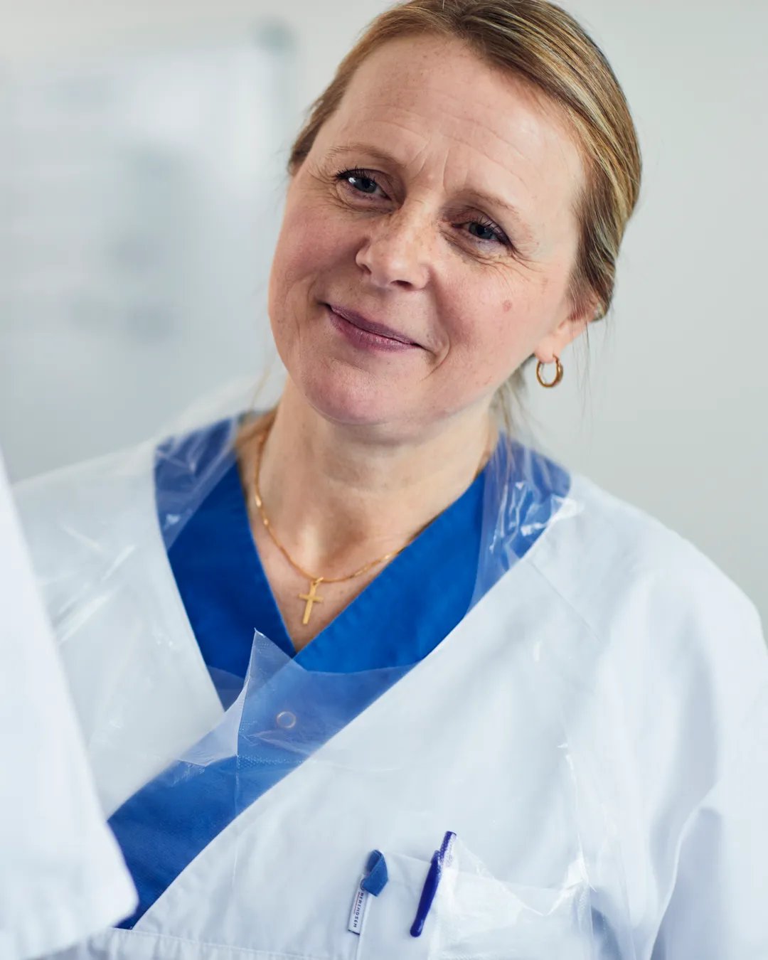 En kvinna i vit labbrock pratar med en annan kvinna.