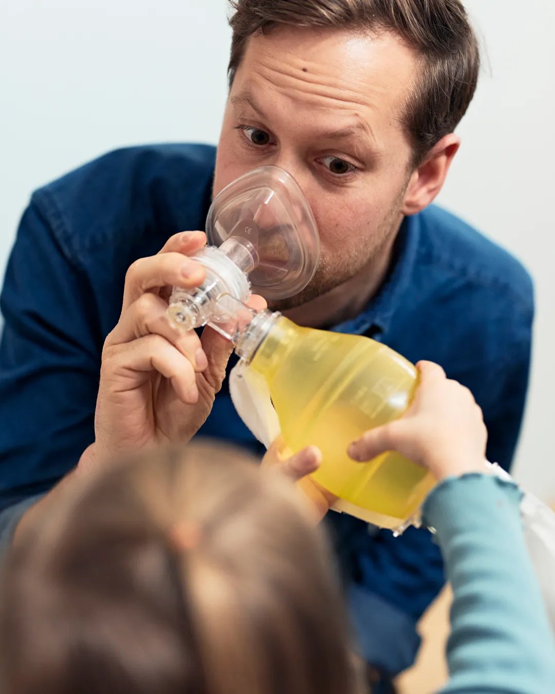 En pappa visar för sin lilla dotter att det är tryggt att andas medicinsk syrgas.