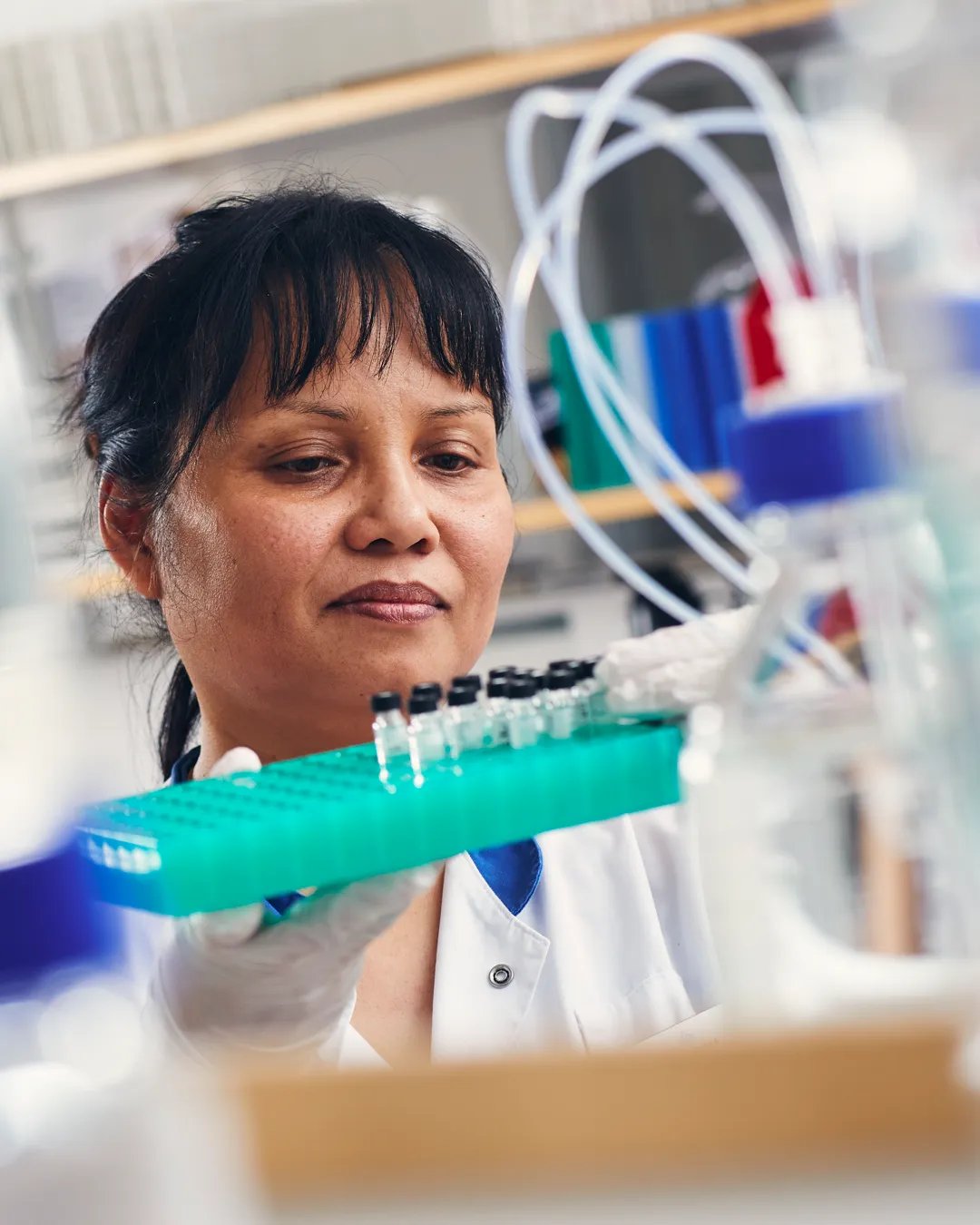 A woman in a lab holding a toothbrush.