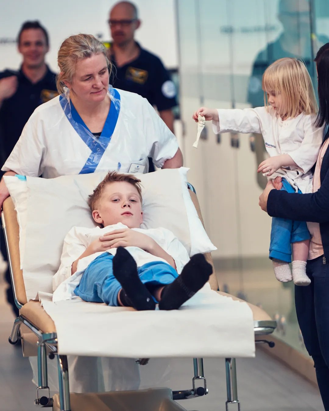 En kvinna skjutsar ett barn i en sjukhussäng.