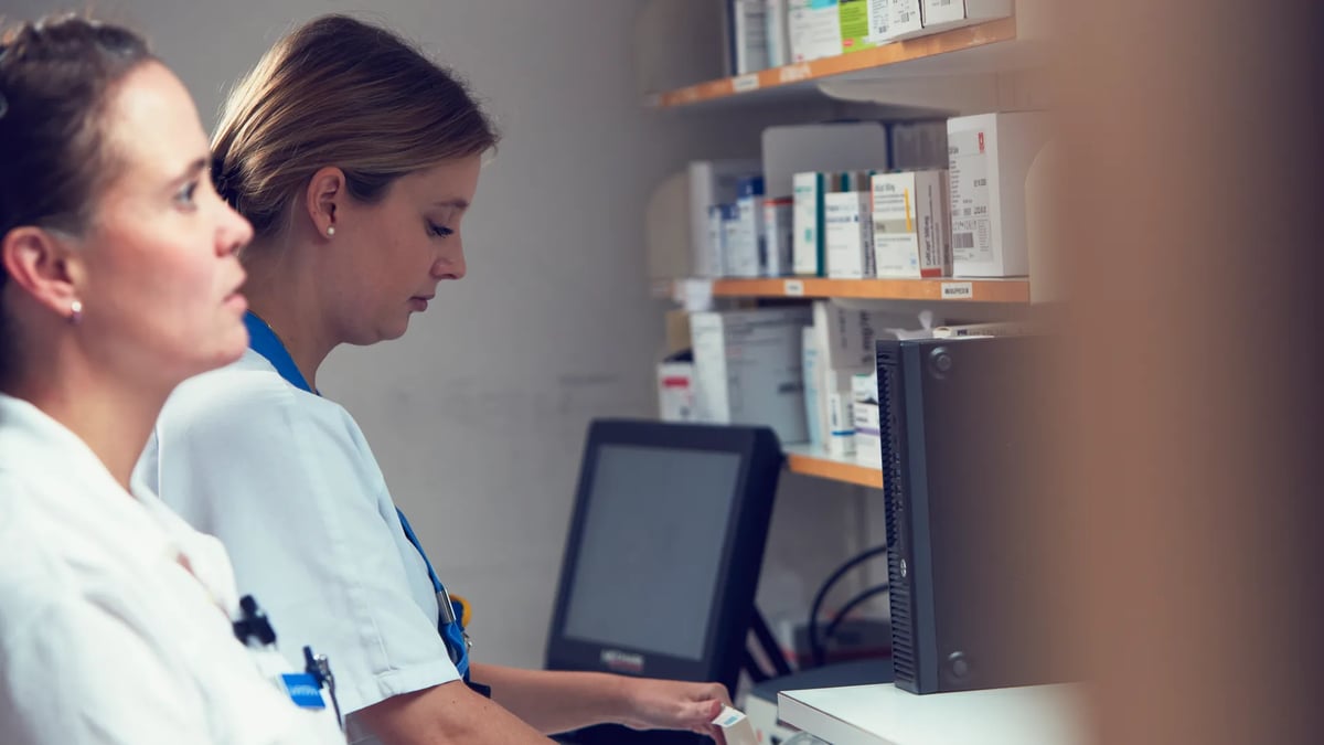 Två kvinnor arbetar vid en dator på ett apotek.