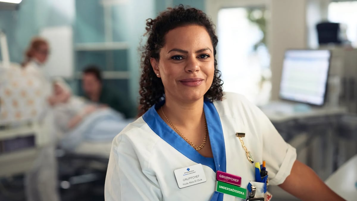 Kvinnlig vårdpersonal i vita arbetskläder.