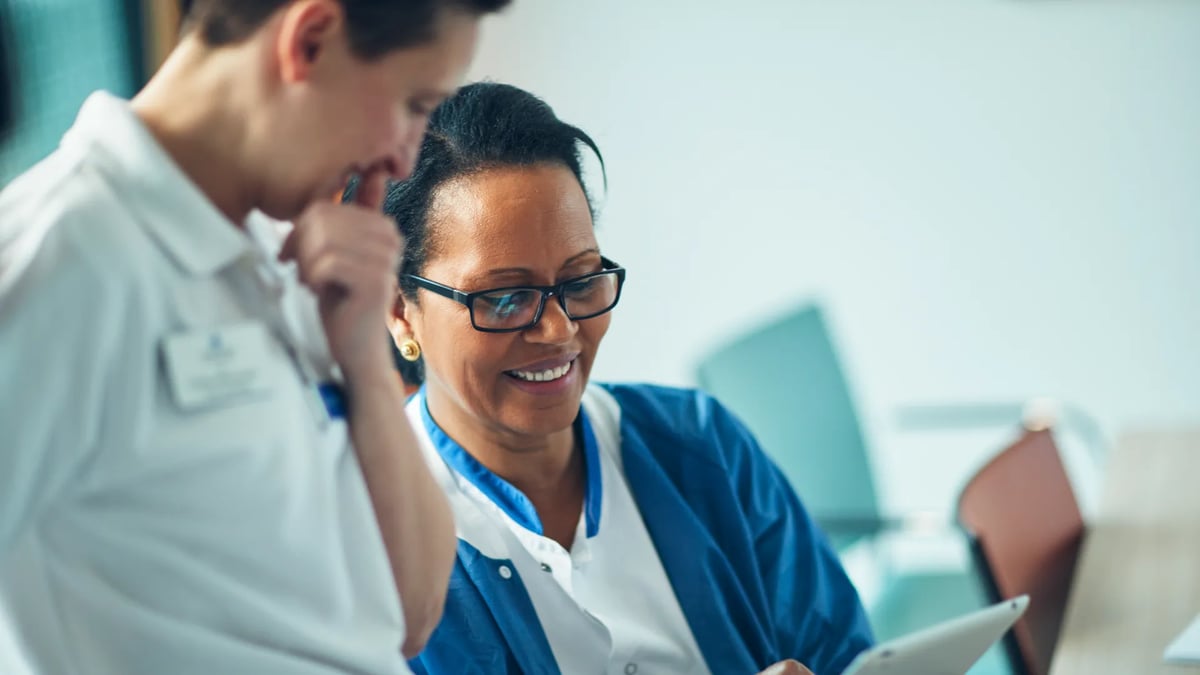 En man och en kvinna tittar på något på en surfplatta.