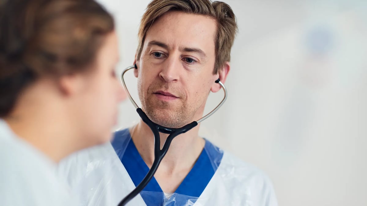 En läkare som pratar med en patient med ett stetoskop.