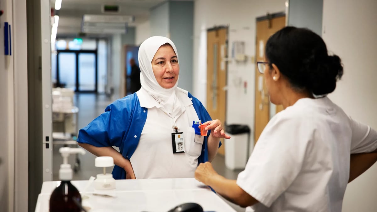 En kvinna pratar med en annan kvinna på ett sjukhus.