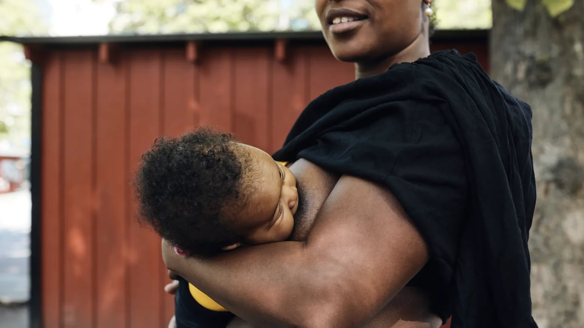 En kvinna med ett spädbarn i famnen.