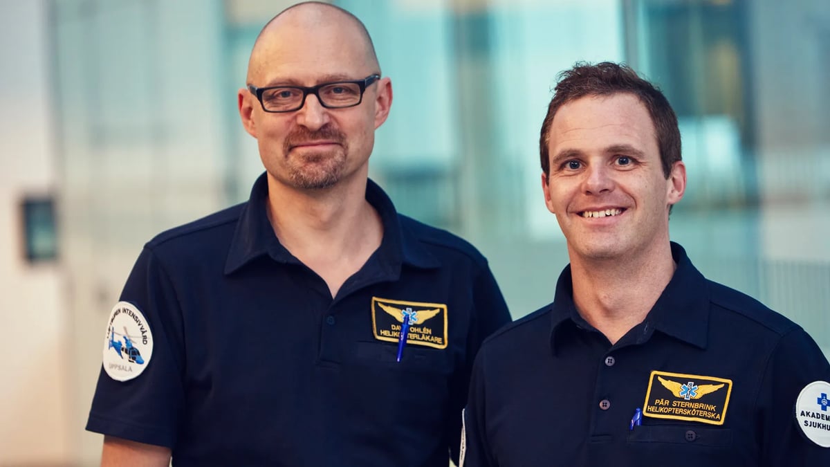 Två män står bredvid varandra framför en byggnad.