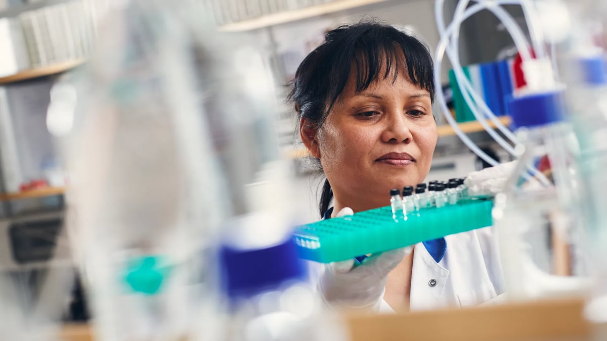 En kvinna i ett laboratorium håller i en tandborste.