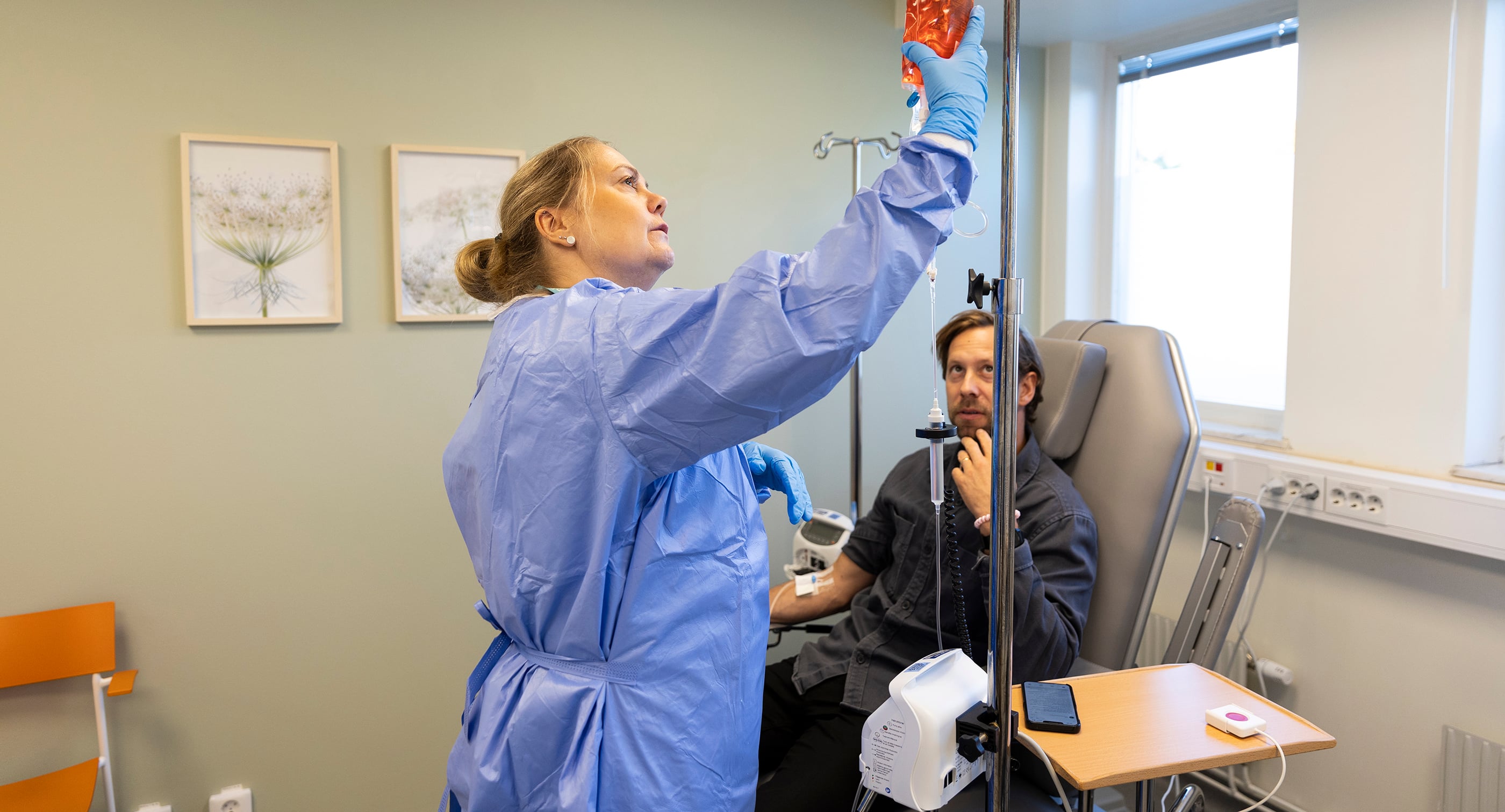 Sedan drygt ett år har Akademiska sjukhuset en behandlingsmottagning för blod- och tumörsjukdomar i Gränby köpcentrum. En ny rapport visar att patienterna uppskattar den lugna och lättillgängliga miljön och att kostnaden per behandling är cirka 50 procent lägre än på sjukhuset. På bilden förbereder sjuksköterskan Johanna Nilsson en behandling. (Arrangerad bild)