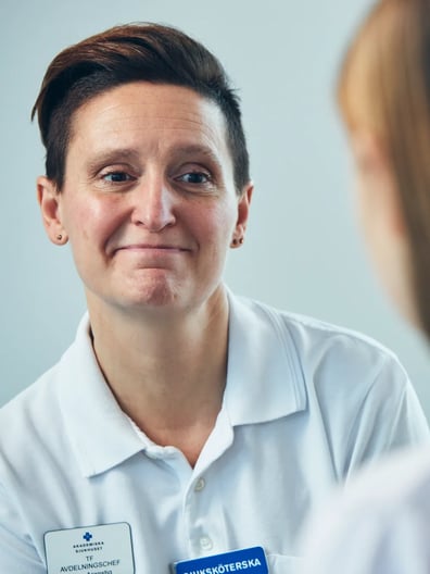 En sjuksköterska pratar med en patient.