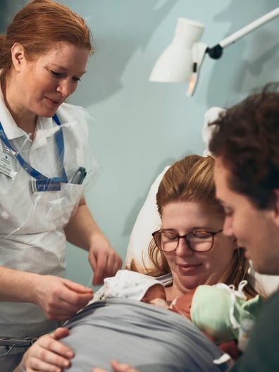 En sjuksköterska tar hand om en nybliven mamma.