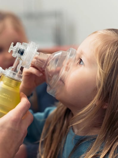 En liten flicka som får hjälp att andas.