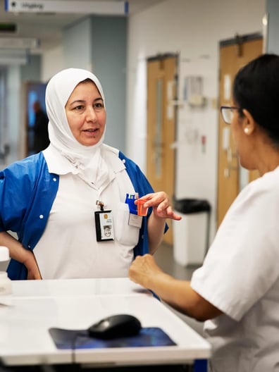 A woman is talking to another woman in a hospital.