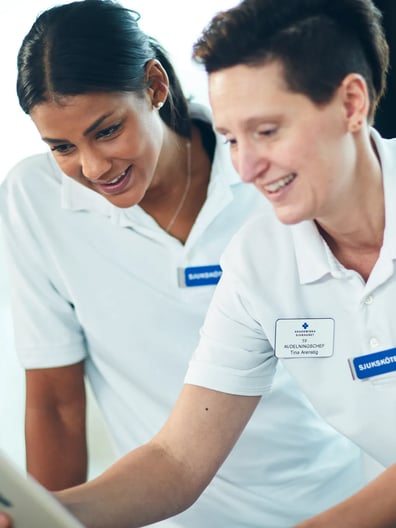 Två sjuksköterskor tittar på en ipad.