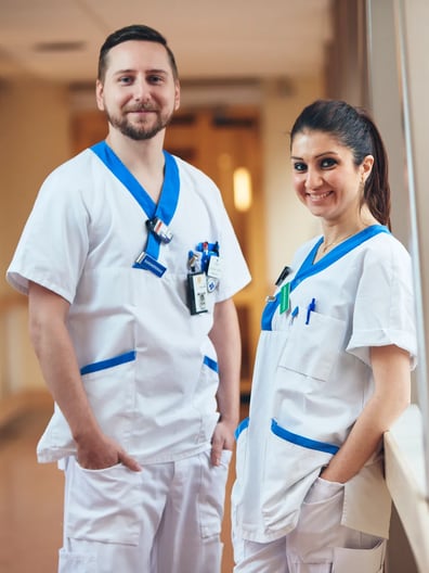 En man och en kvinna i vita arbetskläder står bredvid varandra.