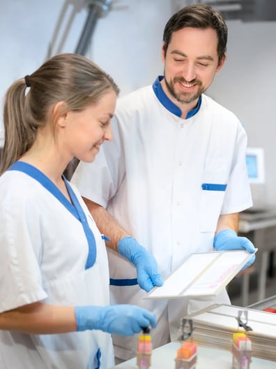 A man and a woman in a lab smiling.