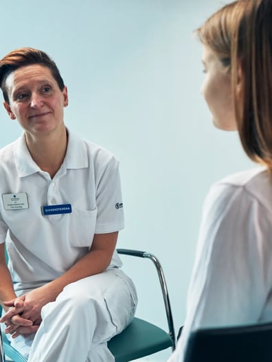 En patient pratar med en sjuksköterska.