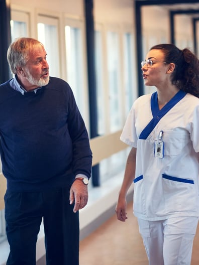 A man and a woman walking down a hallway.