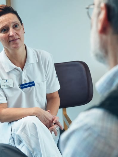 En patient pratar med en sjuksköterska.