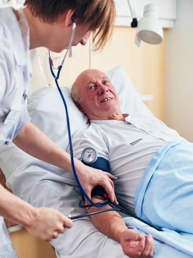 En sjuksköterska kollar en patients blodtryck.