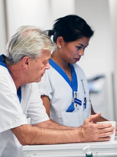 En man och en kvinna tittar på en skärm på ett bord.