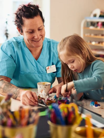 En kvinna och en liten flicka sitter vid ett bord.