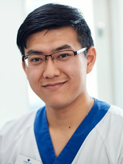 Manlig vårdpersonal i vita arbetskläder.