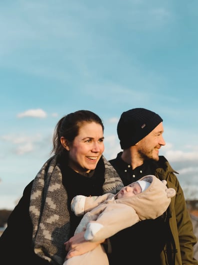 En man och en kvinna som håller en bebis i famnen.