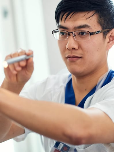 En man i vit skjorta gör något.