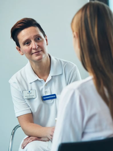 En patient pratar med en sjuksköterska.