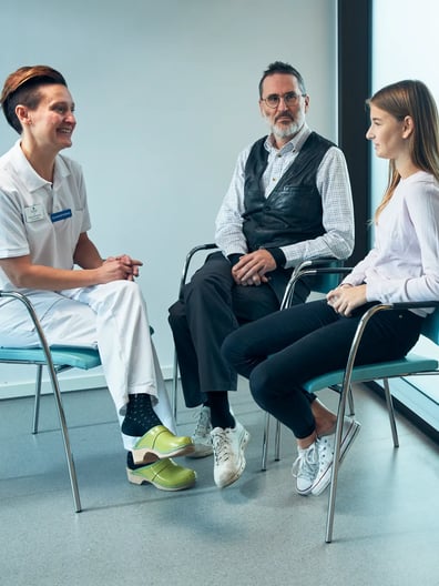 En grupp människor som sitter i stolar och pratar med varandra.