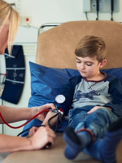 En ung pojke undersöks av en läkare.