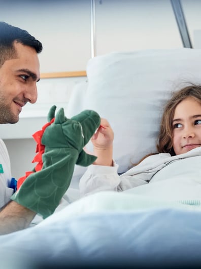 A man makes a hospitalized girl smile.