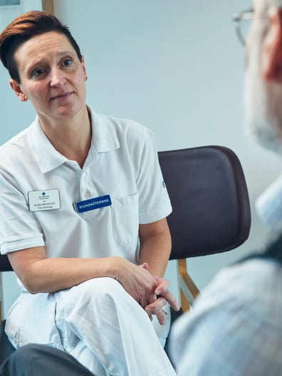 En psykolog sitter i en stol och pratar med en man.