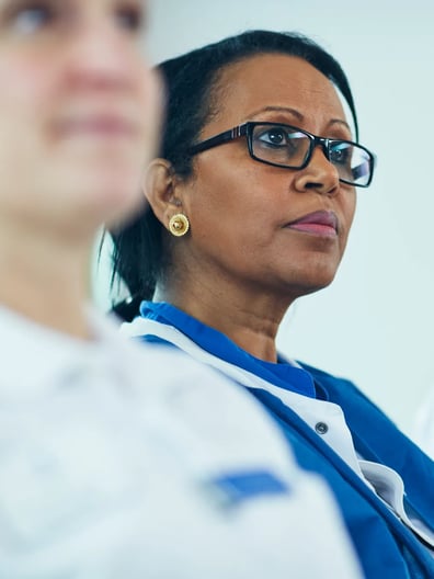 Två kvinnor sitter bredvid varandra och lyssnar på en föreläsning.